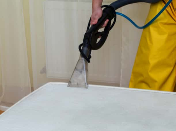 This is a photo of a man steam cleaning a dirty mattress works carried out by Hendon Carpet Cleaning