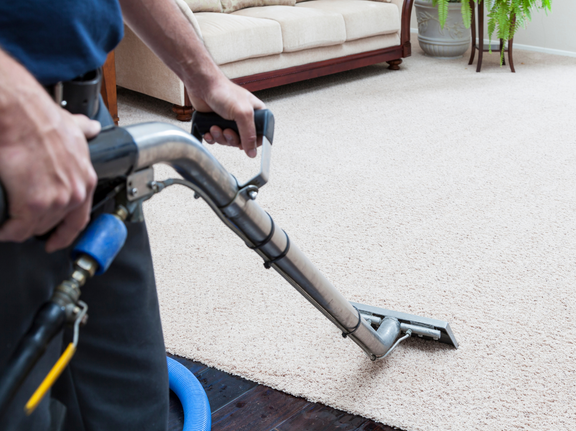 This is a photo of a man with a steam cleaner cleaning a cream carpet works carried out by Hendon Carpet Cleaning